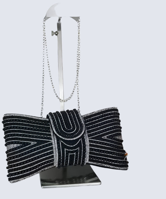 Black beaded clutch bag with a bow on a white background