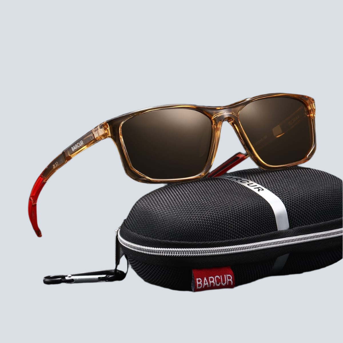 Sunglasses with brown lenses and gold frame on a black case with BARCUR branding.