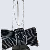 Black beaded clutch bag with a bow on a white background