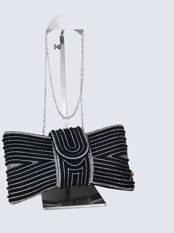 Black beaded clutch bag with a bow on a white background